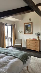 a bedroom with a bed and a chair and a dresser at Stylish Two Bedroom Family Villa in Sopot