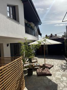 a patio with an umbrella and chairs in front of a house at Stylish Two Bedroom Family Villa in Sopot +9 photos