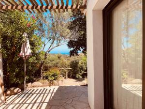 an open door to a patio with an umbrella at Domaine Pietra di Sole in Porto-Vecchio