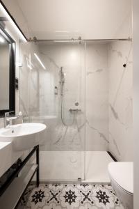 a white bathroom with a shower and a sink at Moja Apartments Krakow Old Town in Krakow +48 photos