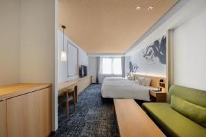 a hotel room with a bed and a couch at Homm Stay Nagi Sanjo Kyoto By Banyan Group in Kyoto +28 photos