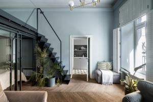 a living room with blue walls and a staircase at Moja Apartments Krakow Old Town in Krakow