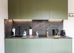 a kitchen with green cabinets and a sink at Limehome Valencia de Xativa in Valencia