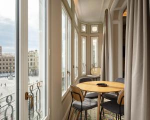 a room with a table and chairs and a window at Limehome Valencia de Xativa in Valencia +40 photos
