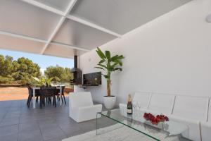 a living room with white furniture and a glass table at Villa Boutique Can Plana in Sant Jordi