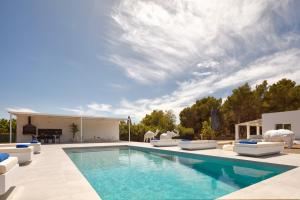a swimming pool with lounge chairs and a house at Villa Boutique Can Plana in Sant Jordi