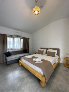 una grande camera da letto con un grande letto e un divano di Luvenza Hotel Alaçatı a Çeşme