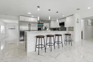 a kitchen with a bar with stools and a refrigerator at Hot Tub - Pet Friendly - Mins to Beach - Sleeps 11 - Family in Clearwater