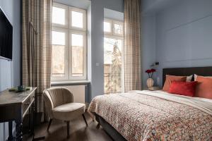 a bedroom with a bed with a desk and a chair at Moja apartments in Kraków
