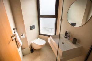 ein Badezimmer mit Toilette, Waschbecken und Spiegel in der Unterkunft Haut Standing 2-Bedroom Apartment in Gauthier in Casablanca + 12 Fotos