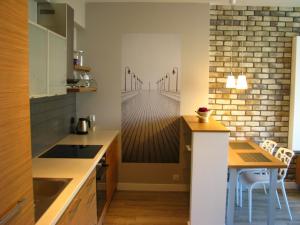 a kitchen with a table and a wooden floor at Apartamenty w centrum Gdyni I in Gdynia