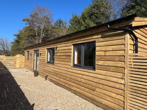a wooden cabin with windows on the side of it at Southend Long Barn in Ogbourne Saint George