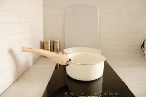a pot on a counter with a wooden spoon at Studio meublé L'écrin doré avec Netflix in Homécourt