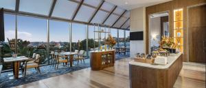 Un restaurante con mesas y sillas y grandes ventanales. en Hilton Istanbul Bosphorus, en Estambul