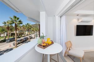 a white room with a table and a view of a street at iloftmalaga Puerto in Málaga