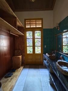 La salle de bains est pourvue de 2 lavabos et d'une porte en bois. dans l'établissement Bently farm retreat Mũi Né- Deluxe Bungalow-01, à Ấp Phú Hiệp