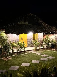 une maison avec une porte jaune la nuit dans l'établissement Bently farm retreat Mũi Né- Deluxe Bungalow-01, à Ấp Phú Hiệp 13 autres photos
