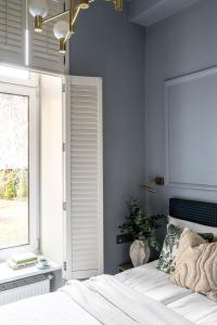 a bedroom with a white bed and a window at Moja apartments in Kraków