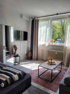 a living room with a couch and a table at Charmante & Gemütliche Wohnung inkl Kaffee und Tee in Wuppertal +7 photos