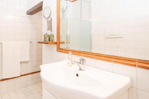 a white bathroom with a sink and a mirror at Pied à terre Cernobbio in Cernobbio