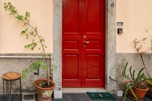 a red door on a building with potted plants at Pied à terre Cernobbio in Cernobbio