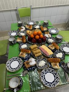 a table topped with plates of food on top at Imran Guest House in Samarkand