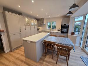 a kitchen with a table and chairs and a kitchen with white cabinets at The Axbridge Hideaway in Axbridge