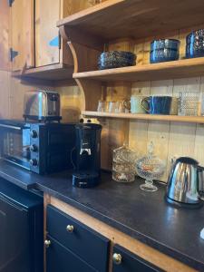 a kitchen counter top with a coffee maker and dishes at La Petite Maison in Gérardmer