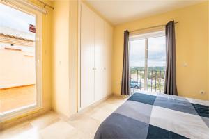 a bedroom with a bed and a large window at Vista Hermosa in Ayamonte