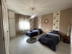 a bedroom with two beds and a window at Gîte Le Calyaden in Athis
