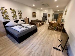 a bedroom with a bed and a living room at NEU Goldstadt Suite Schlössle-Galerie Zentrum Pforzheim in Pforzheim