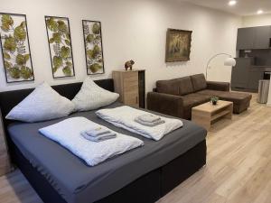 a living room with a bed and a couch at NEU Goldstadt Suite Schlössle-Galerie Zentrum Pforzheim in Pforzheim
