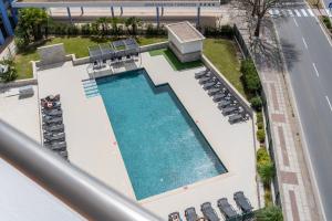 an overhead view of a pool with chairs and a building at Breathtaking Coral Ocean View Apartment at OA in Portimão