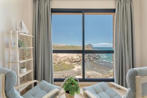 una sala de estar con una gran ventana con vistas al océano en Maresía, en Los Abrigos