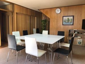 a meeting room with a white table and chairs at Guesthouse NUSA in Kushiro