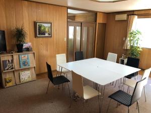 a conference room with a white table and chairs at Guesthouse NUSA in Kushiro +12 photos