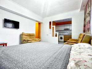 a bedroom with a large bed and two chairs at 05 Апартаменты в центре города - выбор для туриста и деловых поездок in Almaty