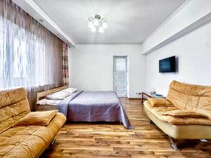 a living room with a couch and a bed at 05 Апартаменты в центре города - выбор для туриста и деловых поездок in Almaty