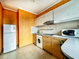 a kitchen with a white refrigerator and a dishwasher at 05 Апартаменты в центре города - выбор для туриста и деловых поездок in Almaty +5 photos