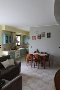 Una cocina y un comedor con mesa y sillas. en Casa Angy, en Galbino
