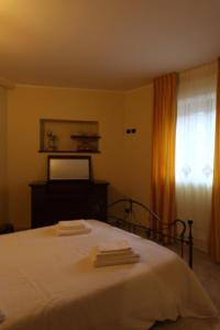 Un dormitorio con una cama con sábanas blancas y una ventana. en Casa Angy, en Galbino