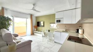 Una cocina y una sala de estar con un sofá y una mesa. en Benalbeach Magic View, en Benalmádena