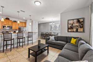 a living room and kitchen with a couch and a table at 8893 Candy Palm Road in Kissimmee