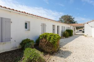 een wit gebouw met struiken ervoor bij Maison N°3 - Résidence Pingettes in Le Bois-Plage-en-Ré