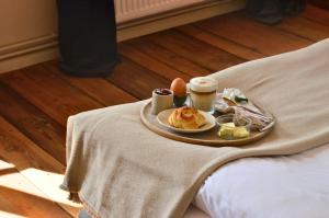 ein Tablett mit Frühstücksspeisen auf einem Bett in der Unterkunft An Den Wiesen Gasthaus am Finowkanal in Wandlitz