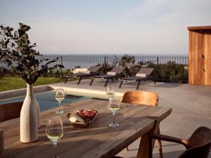 ザキントスにあるAkra Villa, a Cliffside Escape with Pure SeaViews, By ThinkVillaの木製テーブル(ワイングラス付)とフルーツボウル +30枚の写真