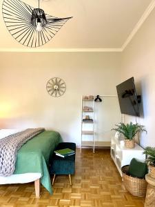 a bedroom with a green bed and a television at APARTMENT KLAGENFURT Villa Frank No3 - with Free Parking, Smart-TV & Self Check-in in Klagenfurt