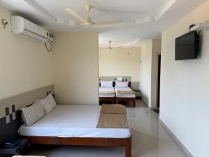 a bedroom with a bed and a tv in it at Bhanu Residency in Tirupati