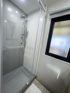 una doccia con porta in vetro accanto a una finestra di Domaine Les Acacias a La Ville-aux-Dames Altre 42 foto