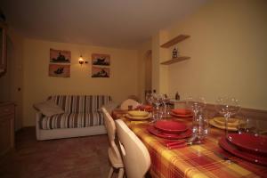 een eetkamer met een tafel met rode gerechten erop bij Appartamenti Cercenà Deluxe in Canazei